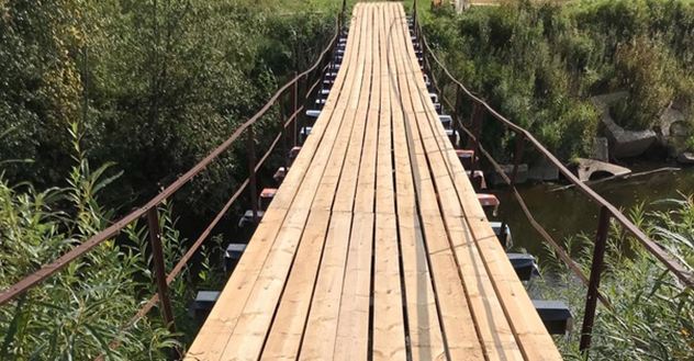 В деревне Шопорово отремонтировали подвесной мост через речку Удима